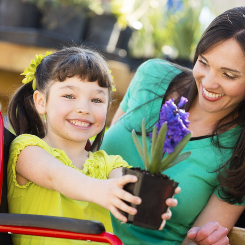 A foster child with a disability is holding flowers.