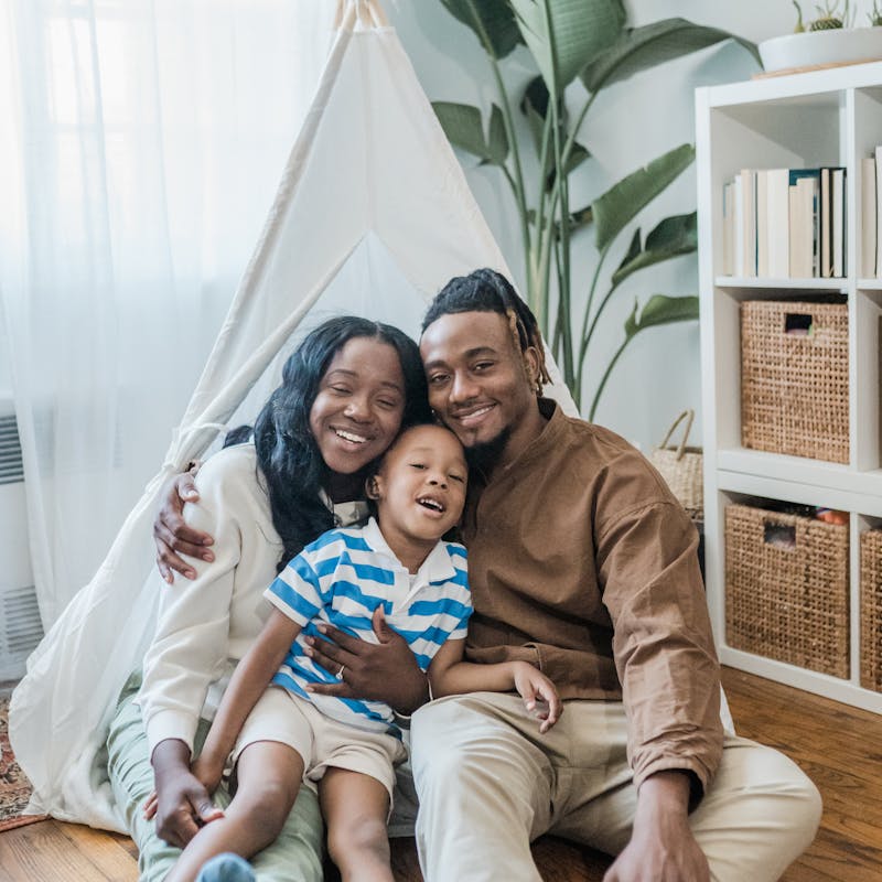 Happy Family Sitting on a Floor in a Living Room